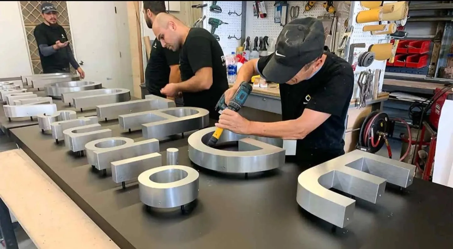 Stainless steel channel letters in fabrication workshop